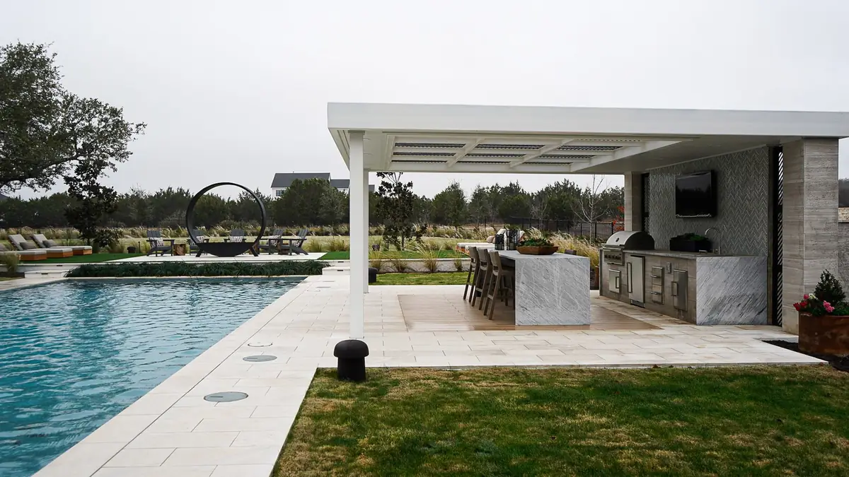 White steel pavilion over a poolside outdoor kitchen