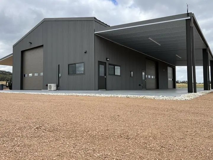 Gray steel shop with a full-length covered bay
