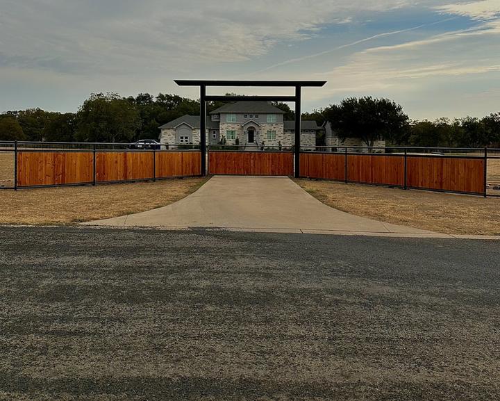 Steel entrance arch with cedar panel fence wings