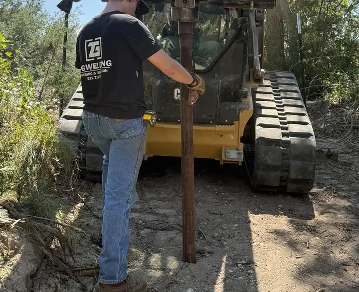 Driving a steel fence post with a skid steer