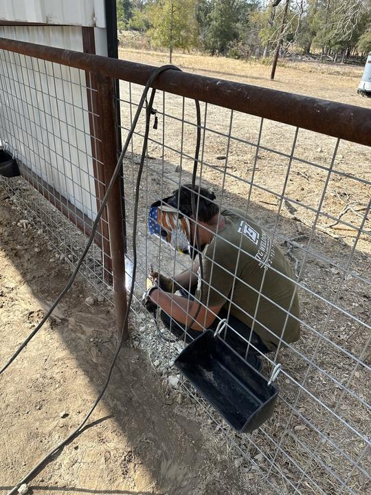 Welding a wire panel to a pipe fence post on site