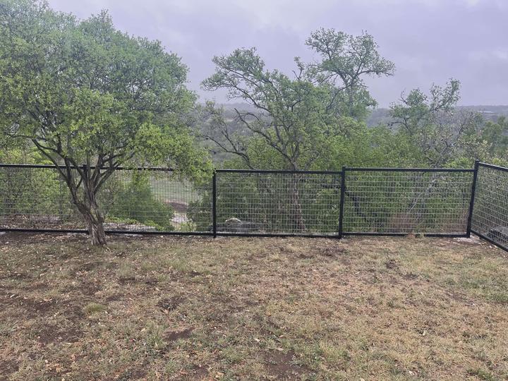 Black steel frame wire panel fence on a hillside