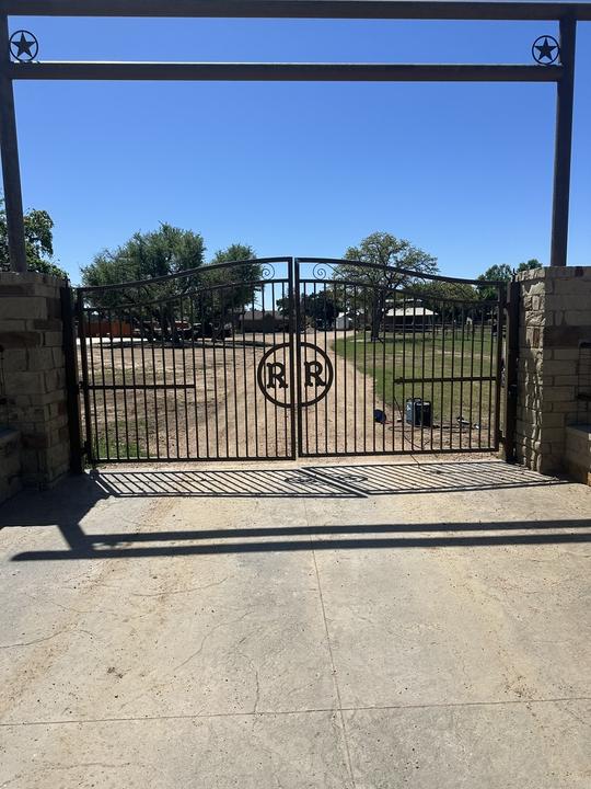 Monogram double swing gate under steel entrance arch