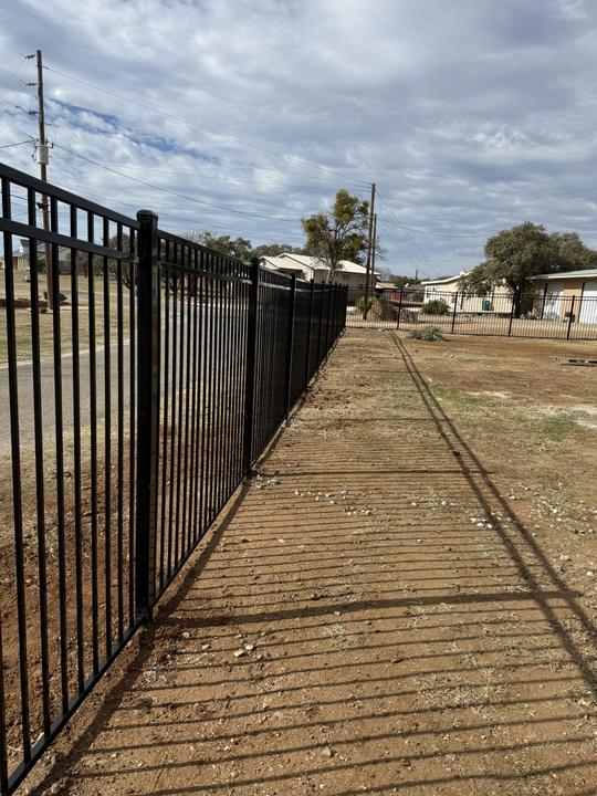 Ornamental steel fence line along the road
