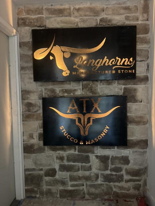 Backlit plasma cut business signs on stone wall