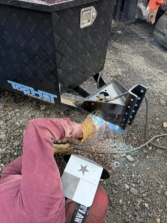 Close-up of a hitch weld in the gravel