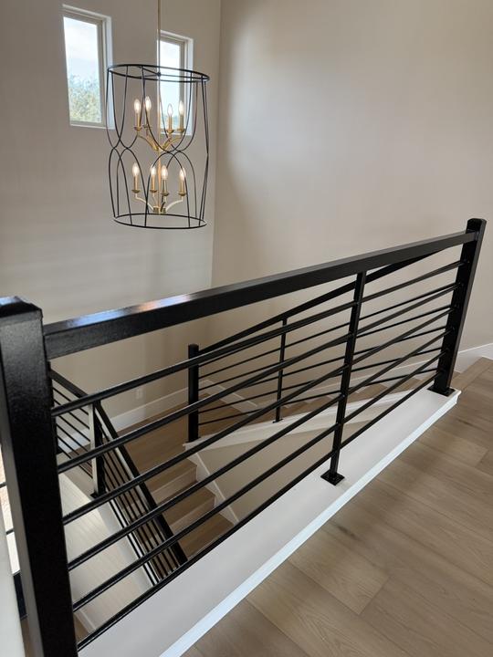 Black horizontal bar rail at upstairs stair landing