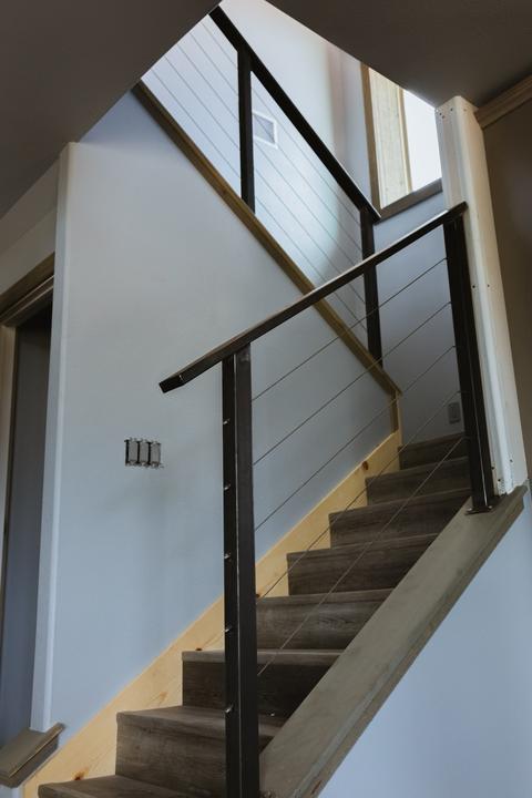 Steel post and cable stair rail with wood cap