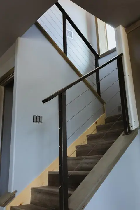 Steel post and cable stair rail with wood cap