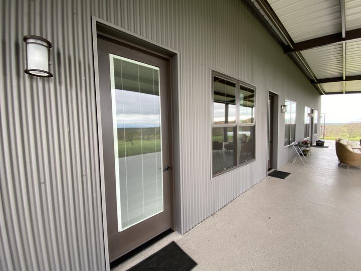 Porch side of a steel home with glass doors