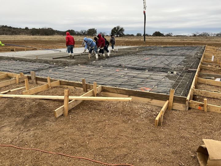 Crew pouring a reinforced slab for a steel building