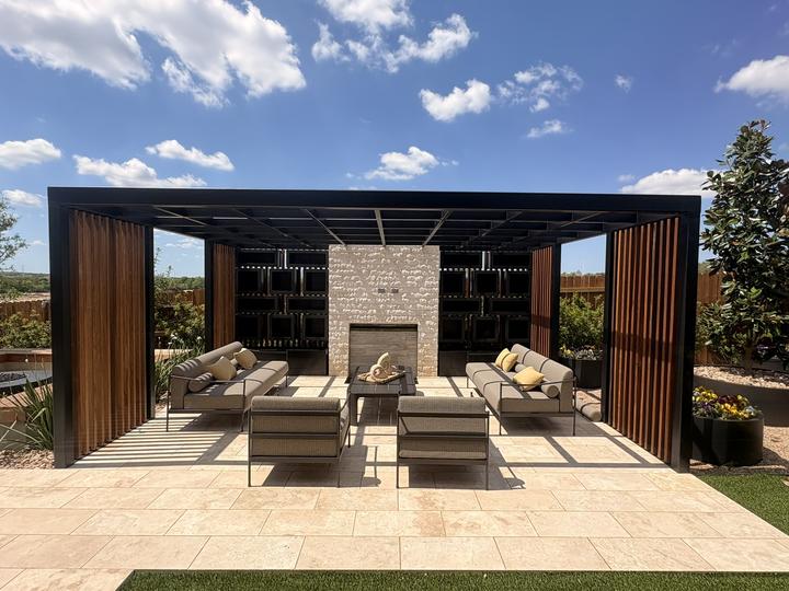 Steel pergola with slat walls and stone fireplace