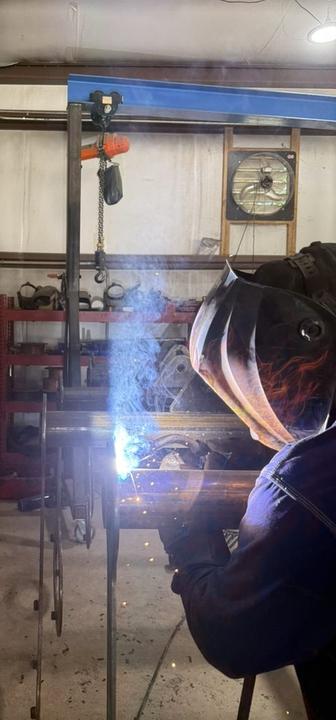 Welding pipe under the shop's overhead hoist