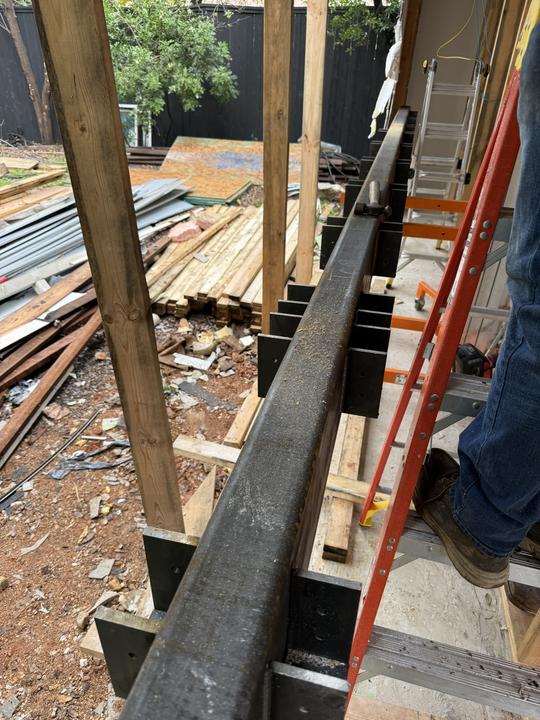 Steel beam with welded plates set in wall framing