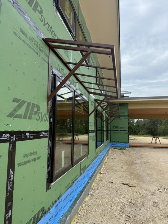 Steel awning frames set over windows on a new build